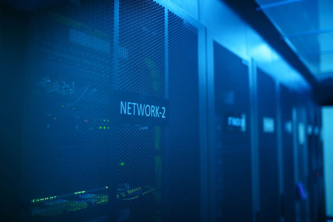 Data centre aisle of network racks under blue light