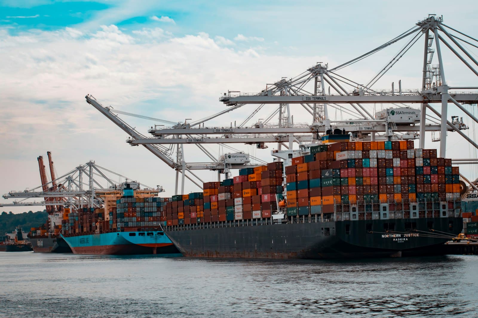 Container ship in port at dusk representing global shipping operations (photo by Vidar Nordli-Mathisen on Unsplash)