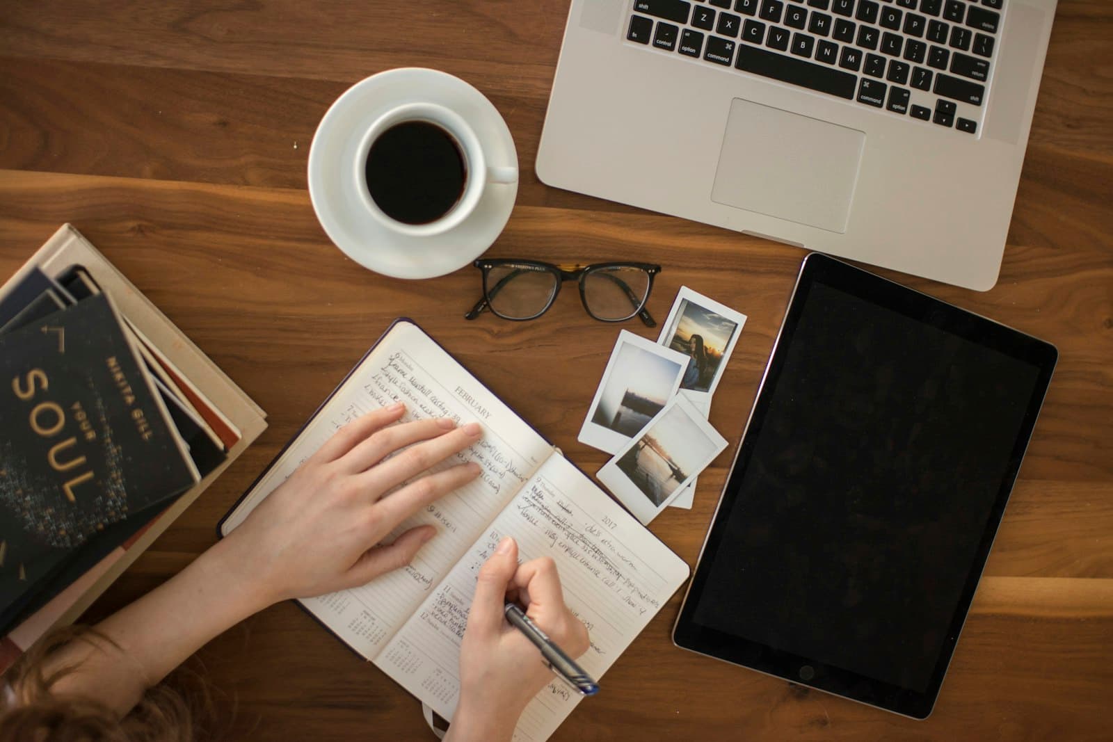 Workspace with a laptop and notebooks, representative of combining digital and written learning.