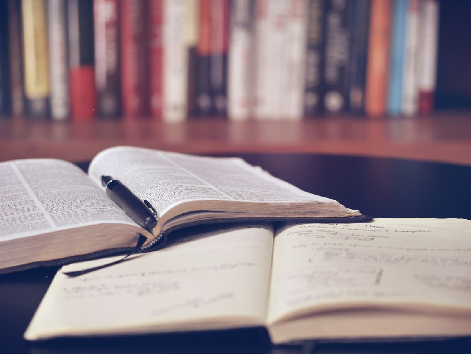 Open notebook with a pen, representative of note-taking through staged readings.