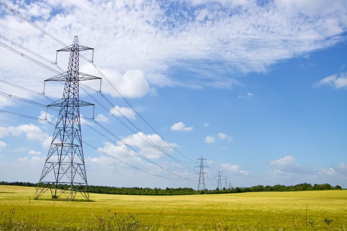 Lattice transmission towers carrying high-voltage lines across farmland